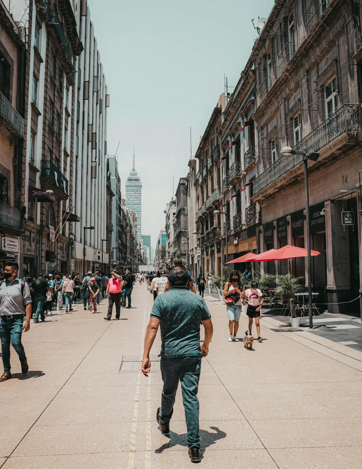 Personas caminando por una calle mexicana con comercios locales